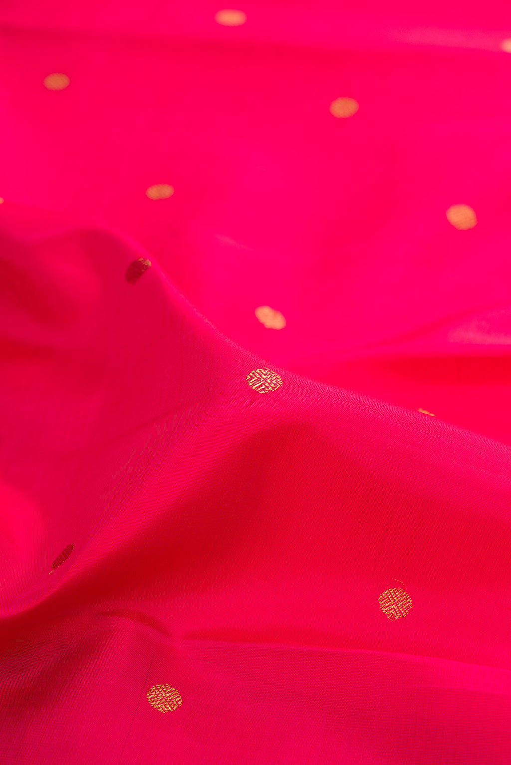 Close up of Pure Silk Pure Zari Dark Pink Kanchipuram Saree with Zari Butta on the body and Zari Border.  displaying folds