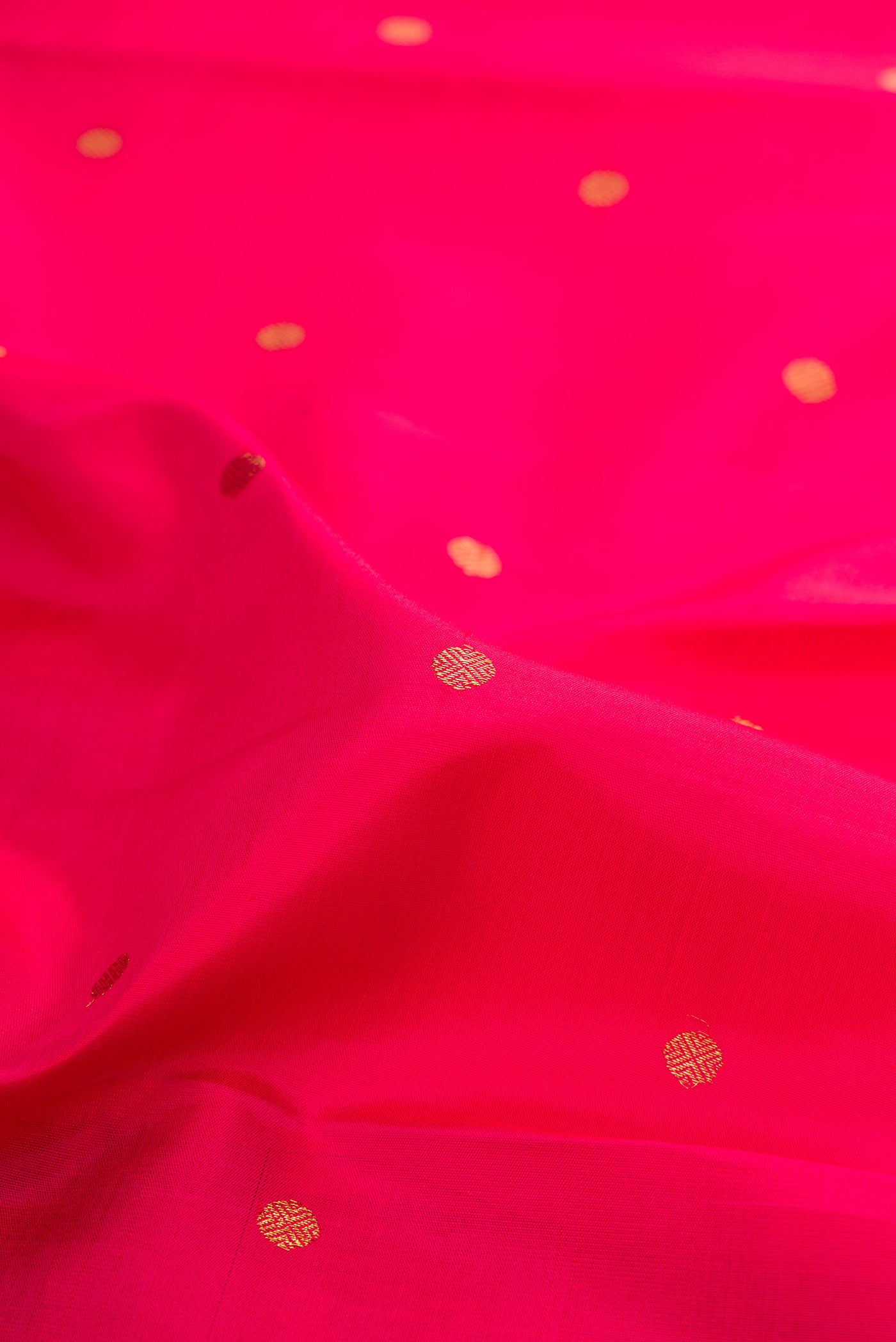 Close up of Pure Silk Pure Zari Dark Pink Kanchipuram Saree with Zari Butta on the body and Zari Border.  displaying folds