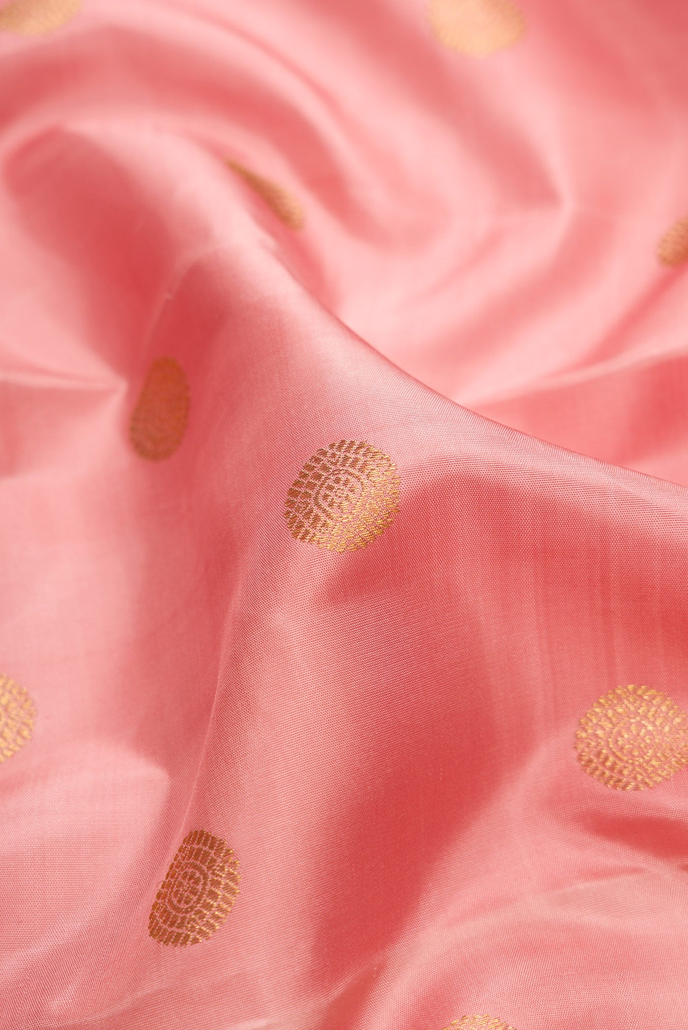 Close up of Pure Silk Pure Zari Golden Peach Dual Tone Kanjivaram Saree with Zari Butta on the body and Zari Border.  displaying folds