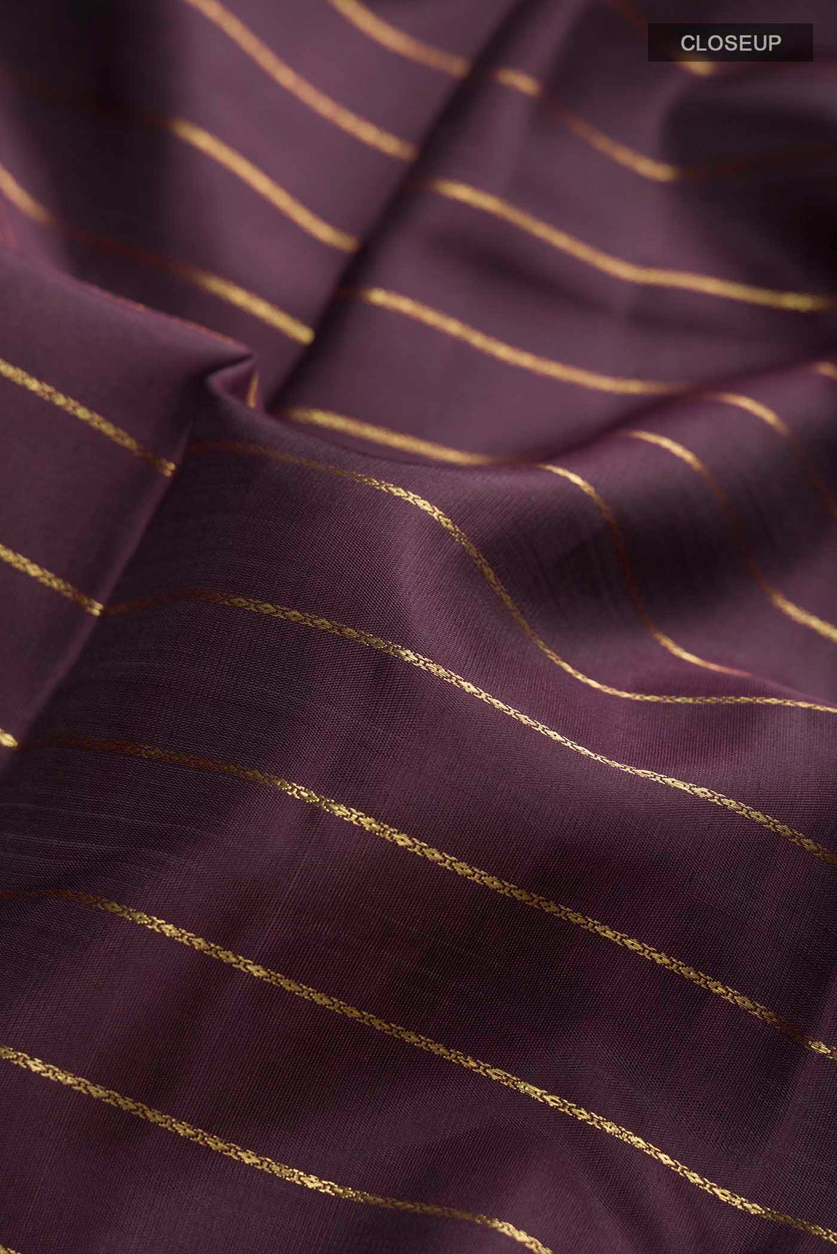 Close up of Brown Kanchipuram Silk Saree with Stripes on the body and Zari Border displaying folds