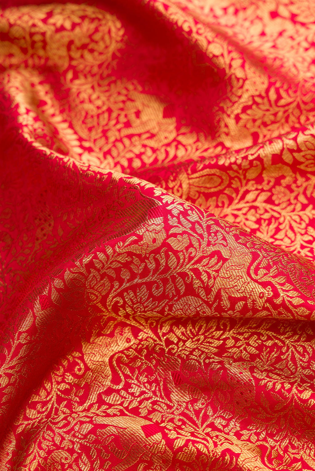Close up of Pure Silk Pure Zari Red Dual Tone Kanjivaram Saree with Zari Brocade on the body and Zari Border.  displaying folds