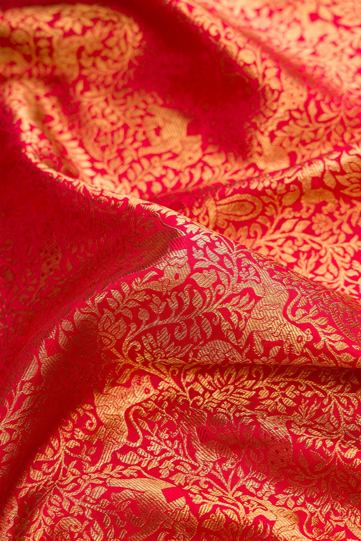 Close up of Pure Silk Pure Zari Red Dual Tone Kanjivaram Saree with Zari Brocade on the body and Zari Border.  displaying folds