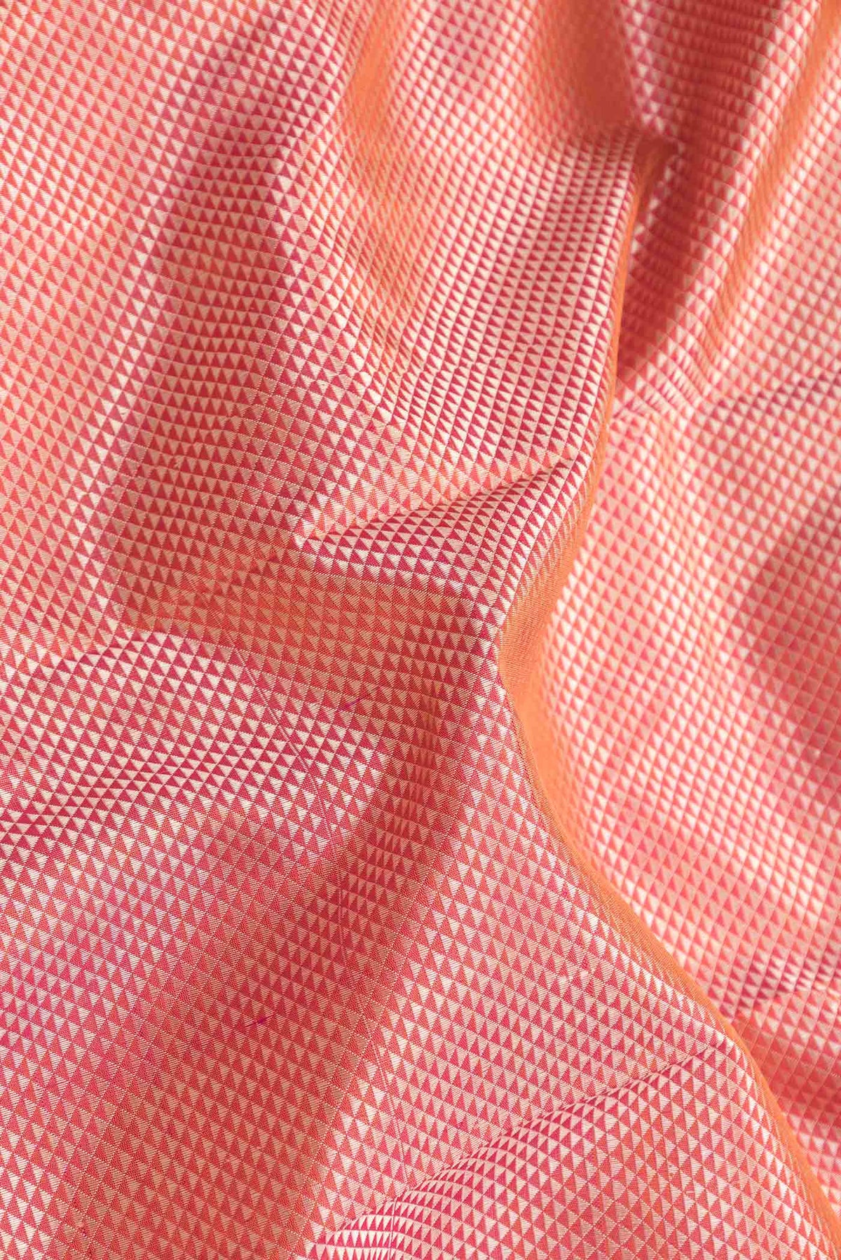 Close up of Pure Silk Pure Zari Orange Dual Tone Kanchipuram SareeJacquard design on the body and Zari Border displaying folds