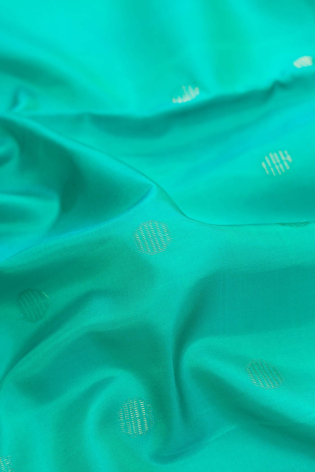 Close up of Sea Green Dual Tone Soft Silk Saree with Zari Butta on the body and Zari Border.  displaying folds