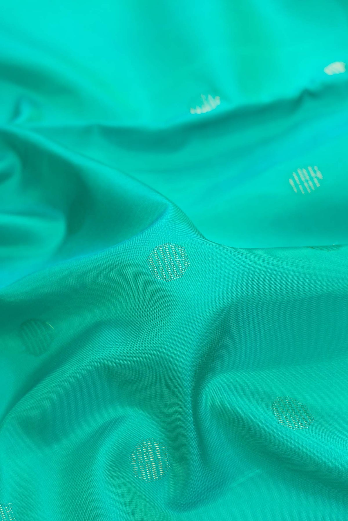 Close up of Sea Green Dual Tone Soft Silk Saree with Zari Butta on the body and Zari Border.  displaying folds