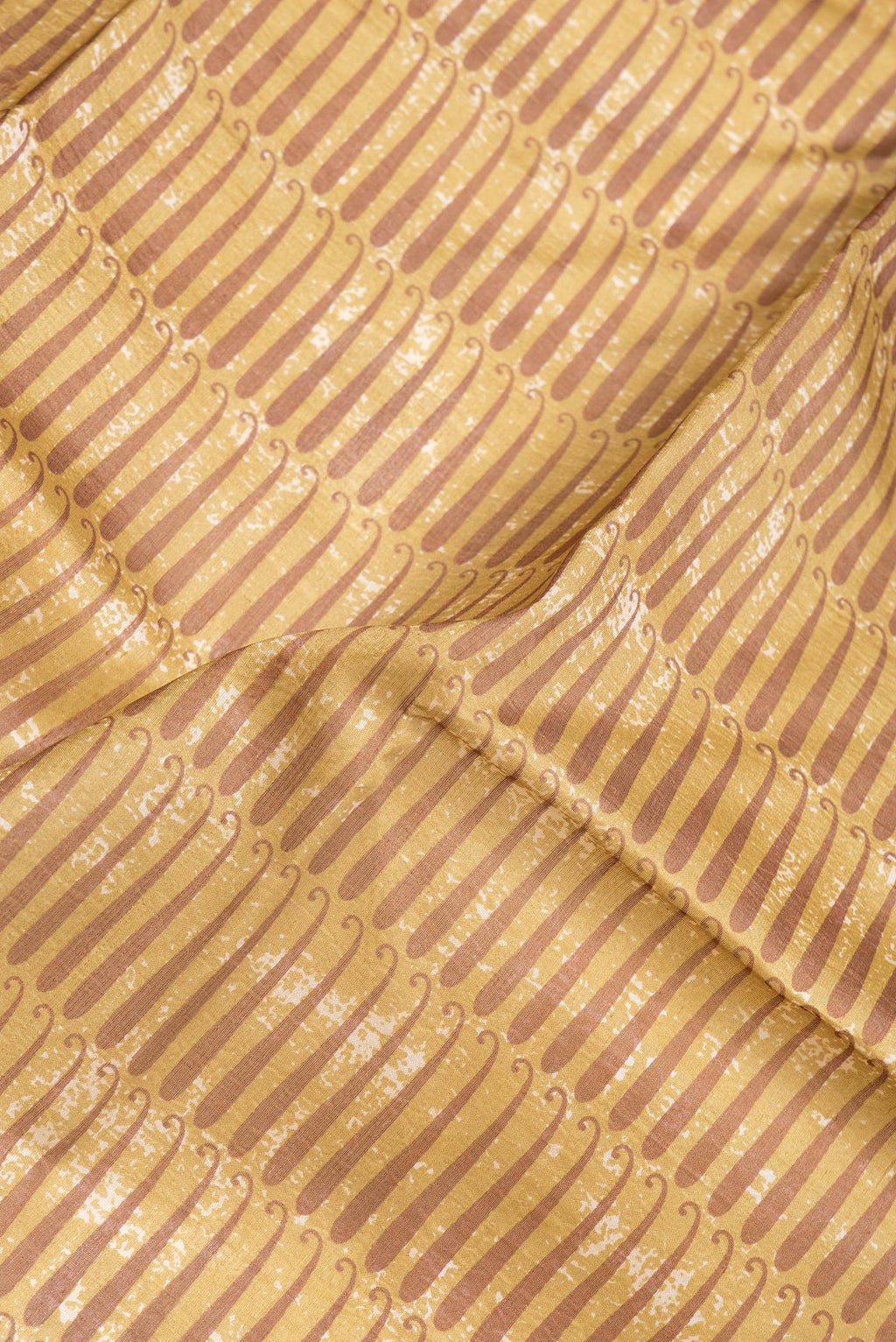 Close up of Mustard Dual Tone Tussar Silk Saree with Printed design on the body and Printed Border.  displaying folds
