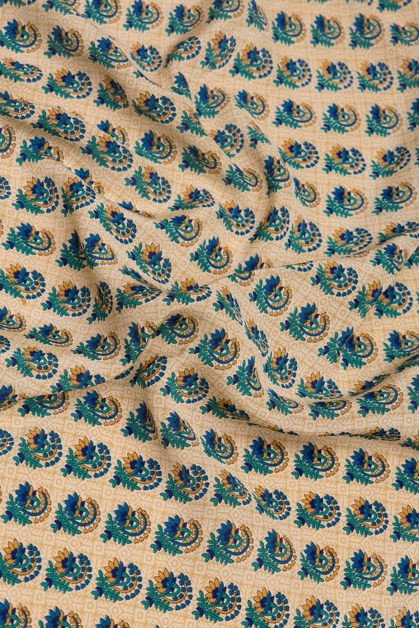 Close up of Beige Crepe Saree with Printed design on the body and Printed Border.  displaying folds