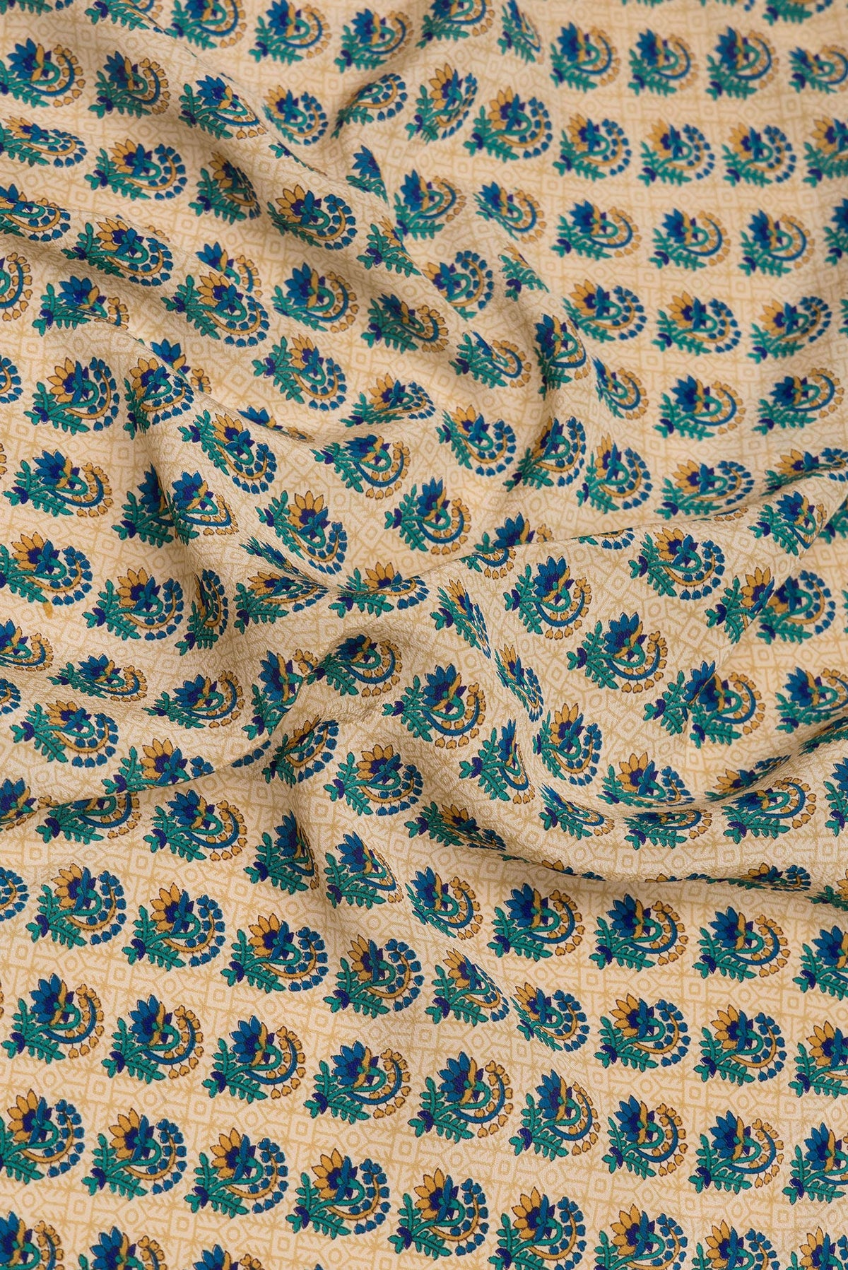 Close up of Beige Crepe Saree with Printed design on the body and Printed Border.  displaying folds