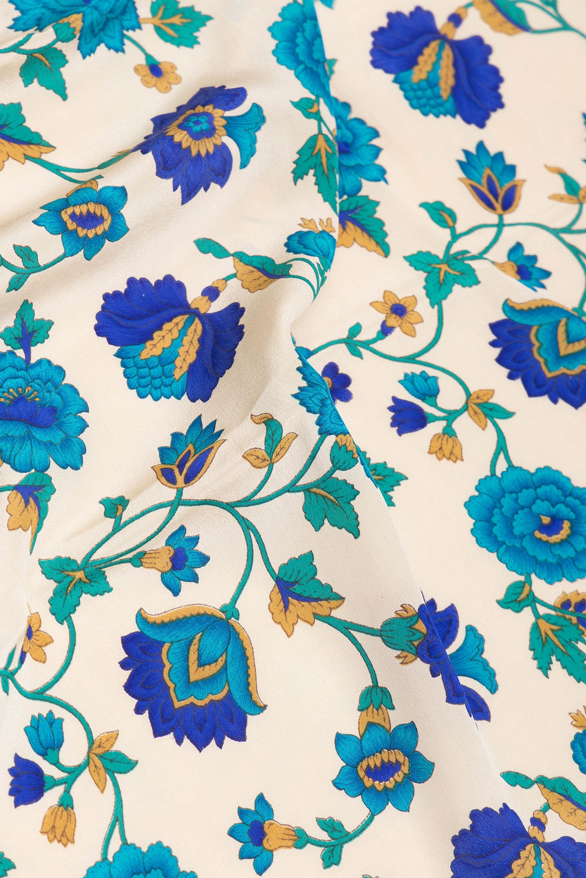 Close up of Beige Crepe Saree with Printed design on the body and Printed Border.  displaying folds
