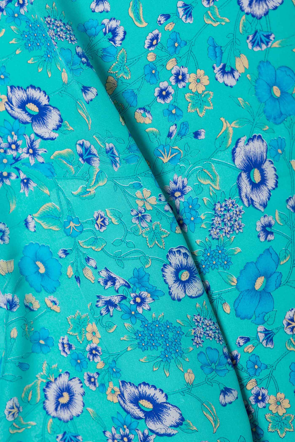 Close up of Sky Blue Dual Tone Mysore Crepe Saree with Printed design on the body and Plain Border displaying folds