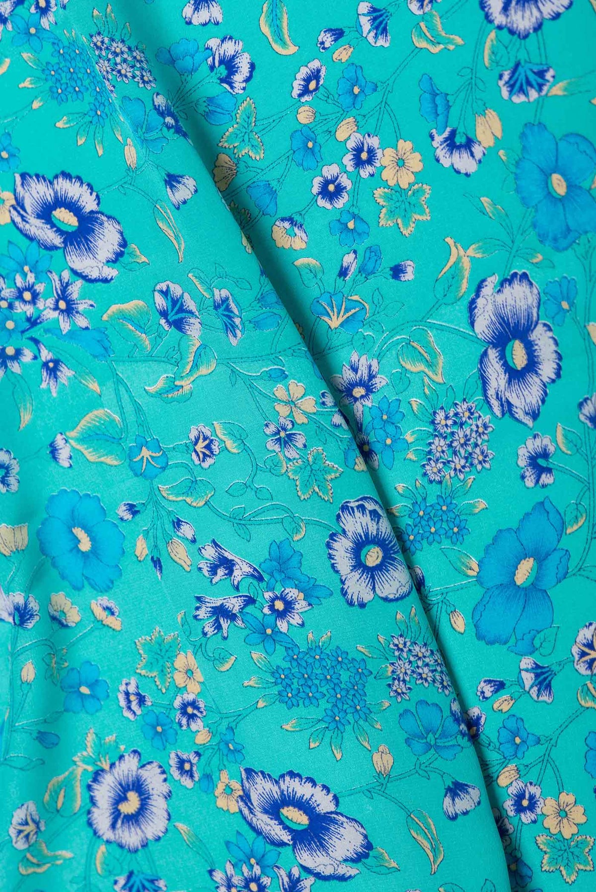 Close up of Sky Blue Dual Tone Mysore Crepe Saree with Printed design on the body and Plain Border displaying folds