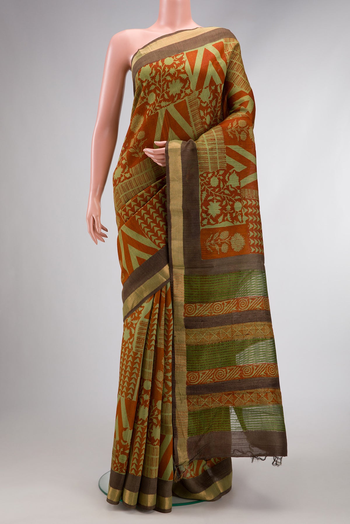 Brick Orange Dual Tone Tussar Silk Saree with Printed design on the body and Zari Border.  displayed on a mannequin
