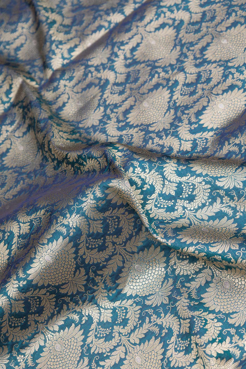 Close up of Peacock Blue Dual Tone Banarasi Silk Saree with Zari Brocade on the body and Zari Border.  displaying folds