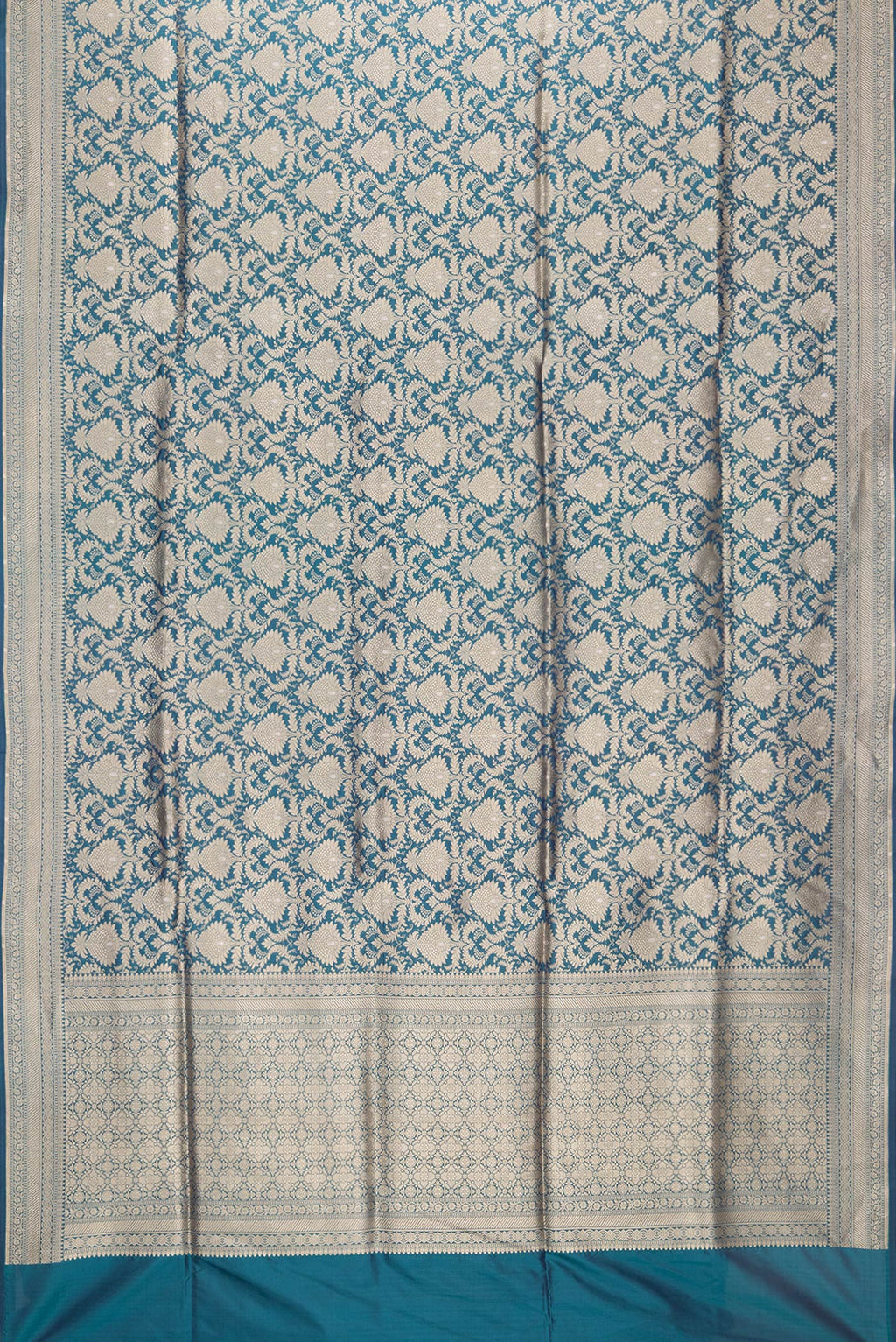 Flat view of Peacock Blue Dual Tone Banarasi Silk Saree with Zari Brocade on the body and Zari Border. 