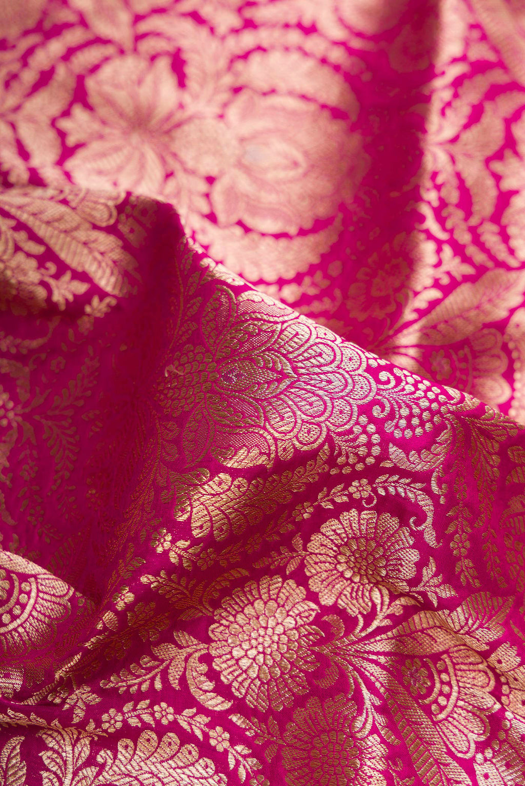 Close up of Magenta Banarasi Silk Saree with Zari Brocade on the body and Fancy Border.  displaying folds