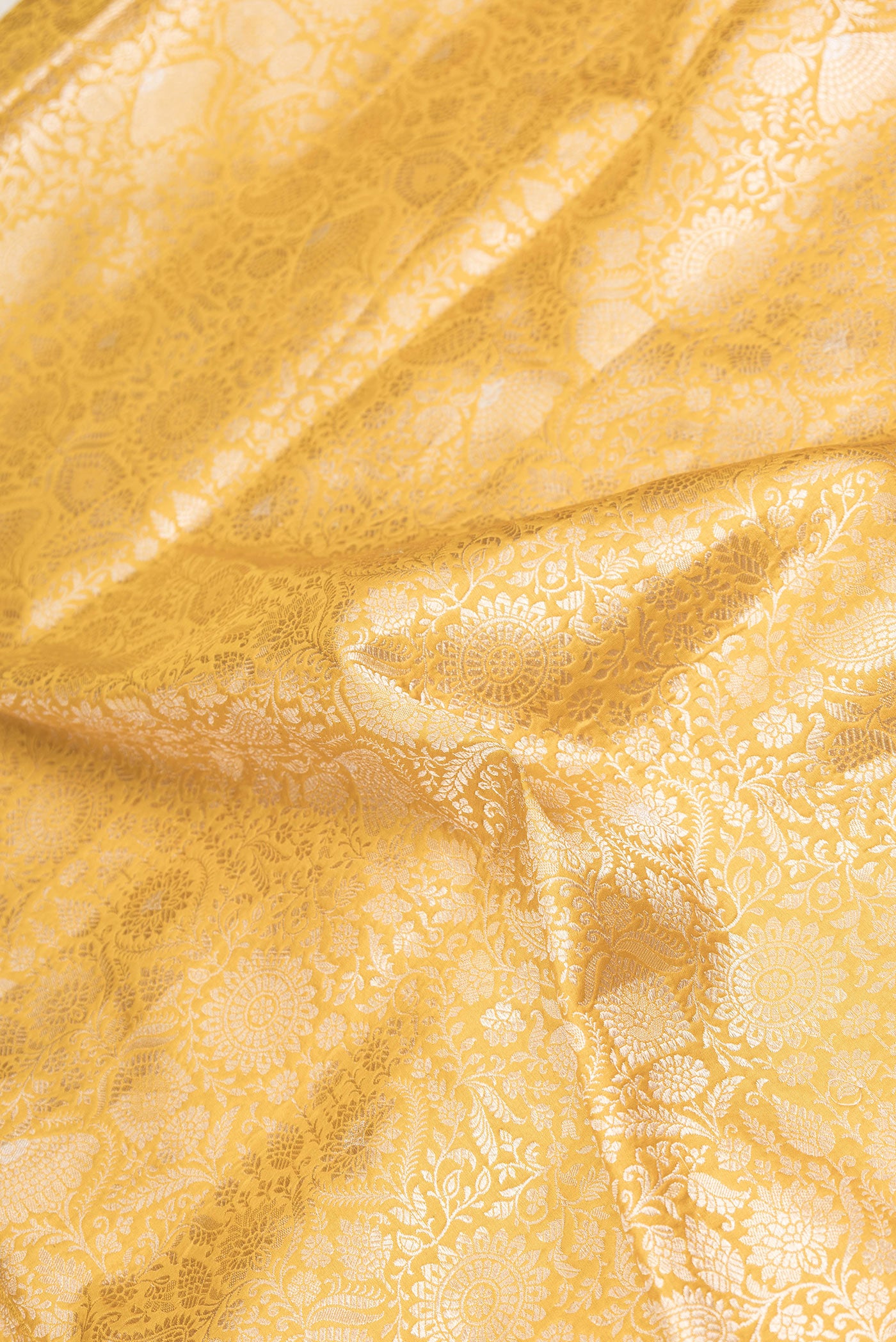Close up of Yellow Dual Tone Banarasi Silk Saree with Zari Brocade on the body and Zari Border.  displaying folds