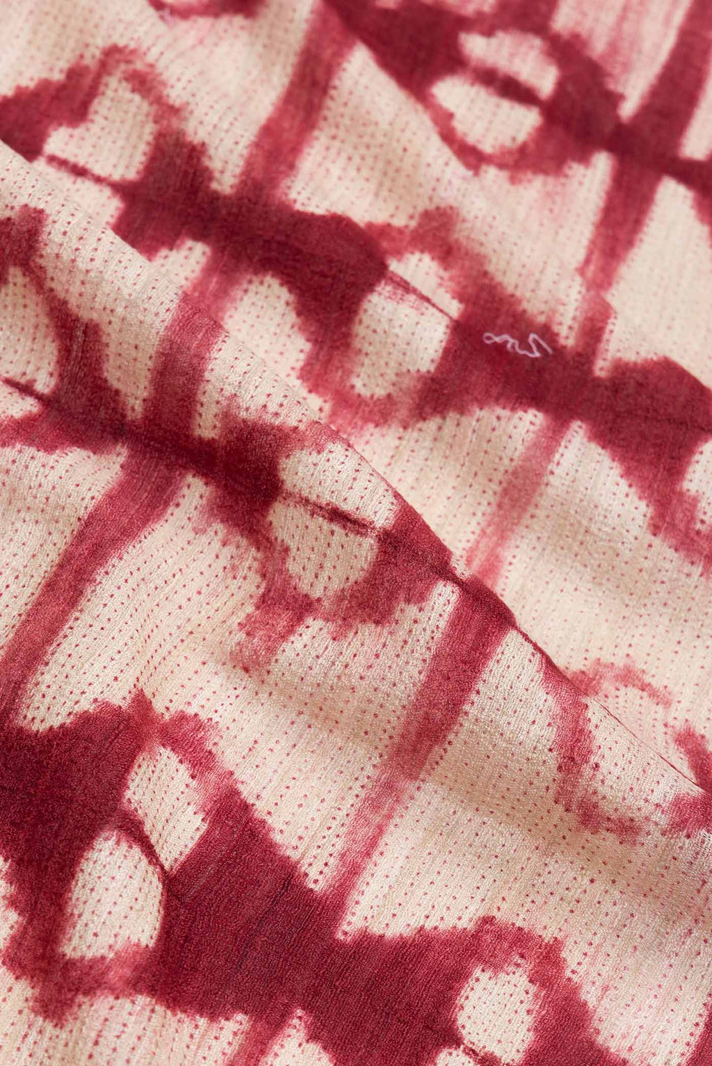 Close up of Beige Dual Tone Tussar Saree with Printed design on the body and Plain Border.  displaying folds