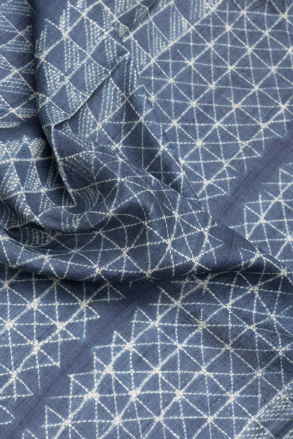 Close up of Navy Blue Dual Tone Tussar Silk Saree with Printed design on the body and Zari Border.  displaying folds