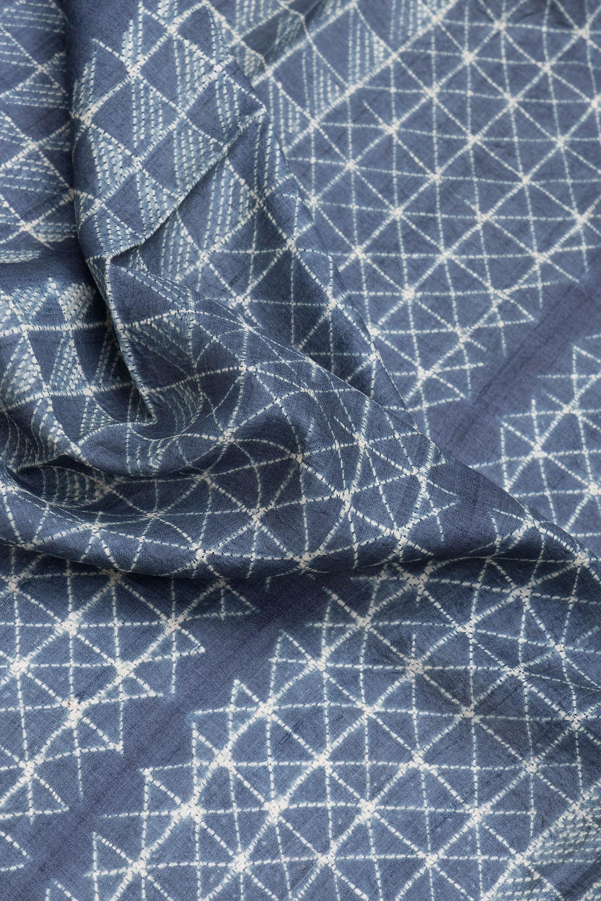 Close up of Navy Blue Dual Tone Tussar Silk Saree with Printed design on the body and Zari Border.  displaying folds