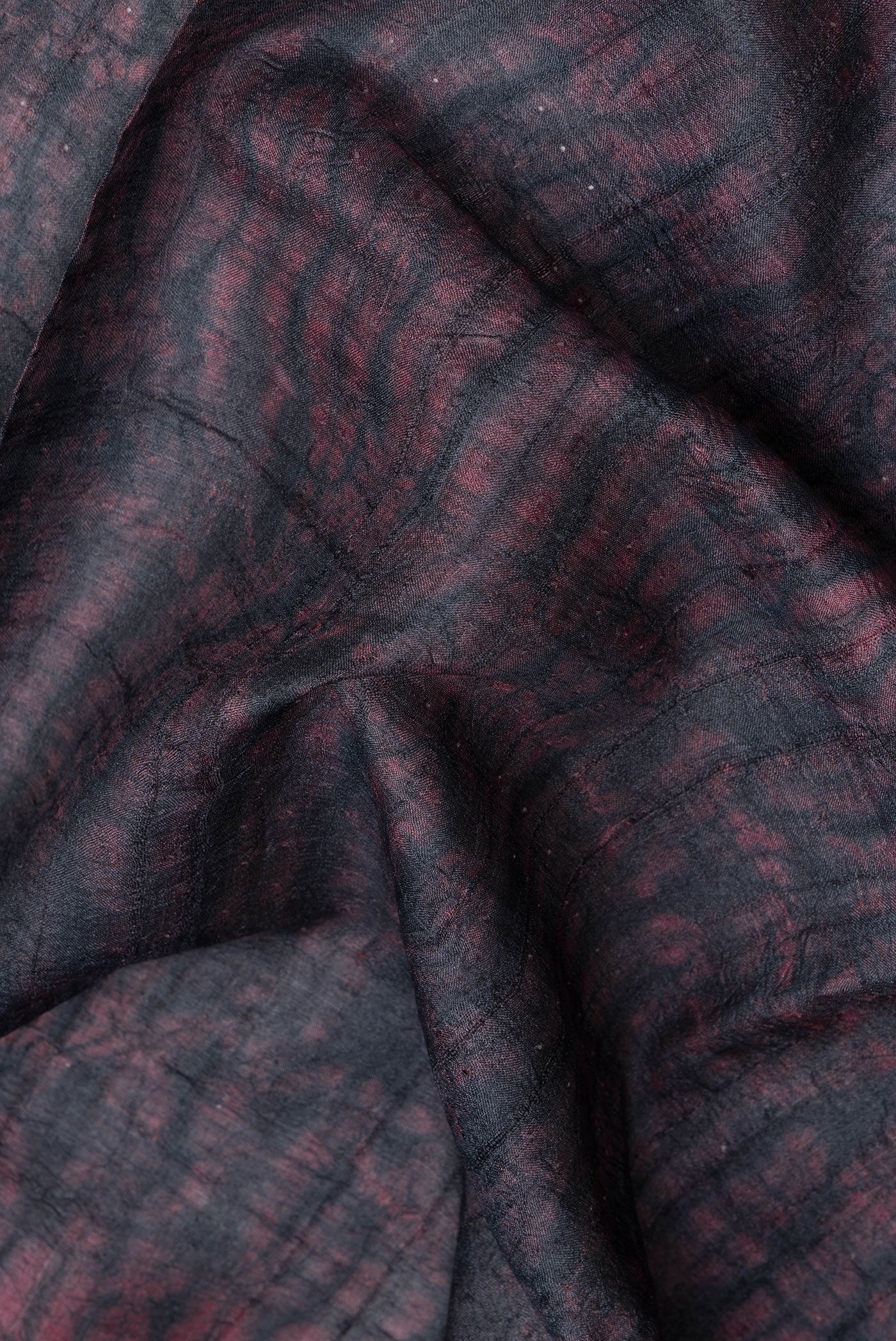 Close up of Maroon Dual Tone Tussar Silk Saree with Printed design on the body and Plain Border.  displaying folds