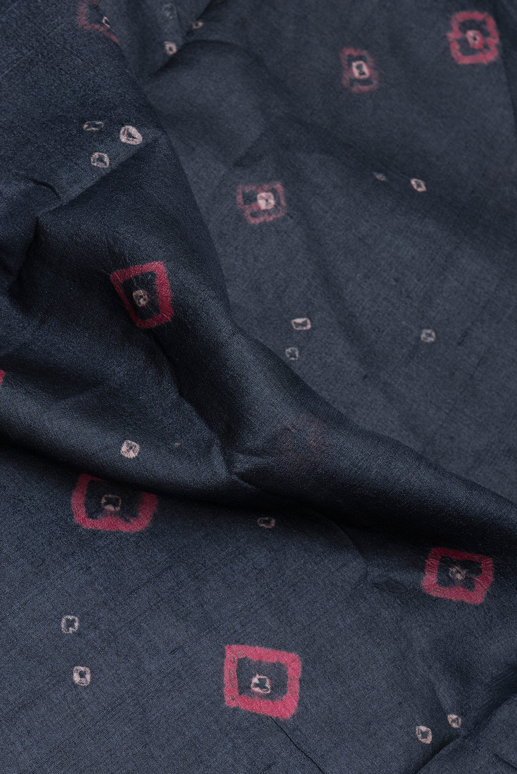 Close up of Black Tussar Silk Saree with Bandhani Print on the body and Printed Border.  displaying folds