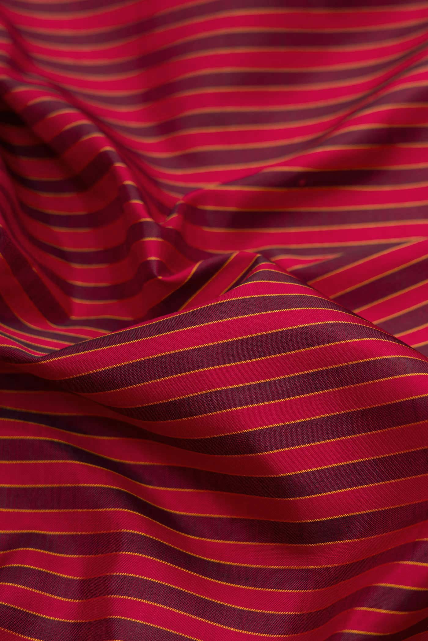 Close up of Maroon Dual Tone Kanchipuram Silk Saree with Stripes on the body and Thread Border displaying folds