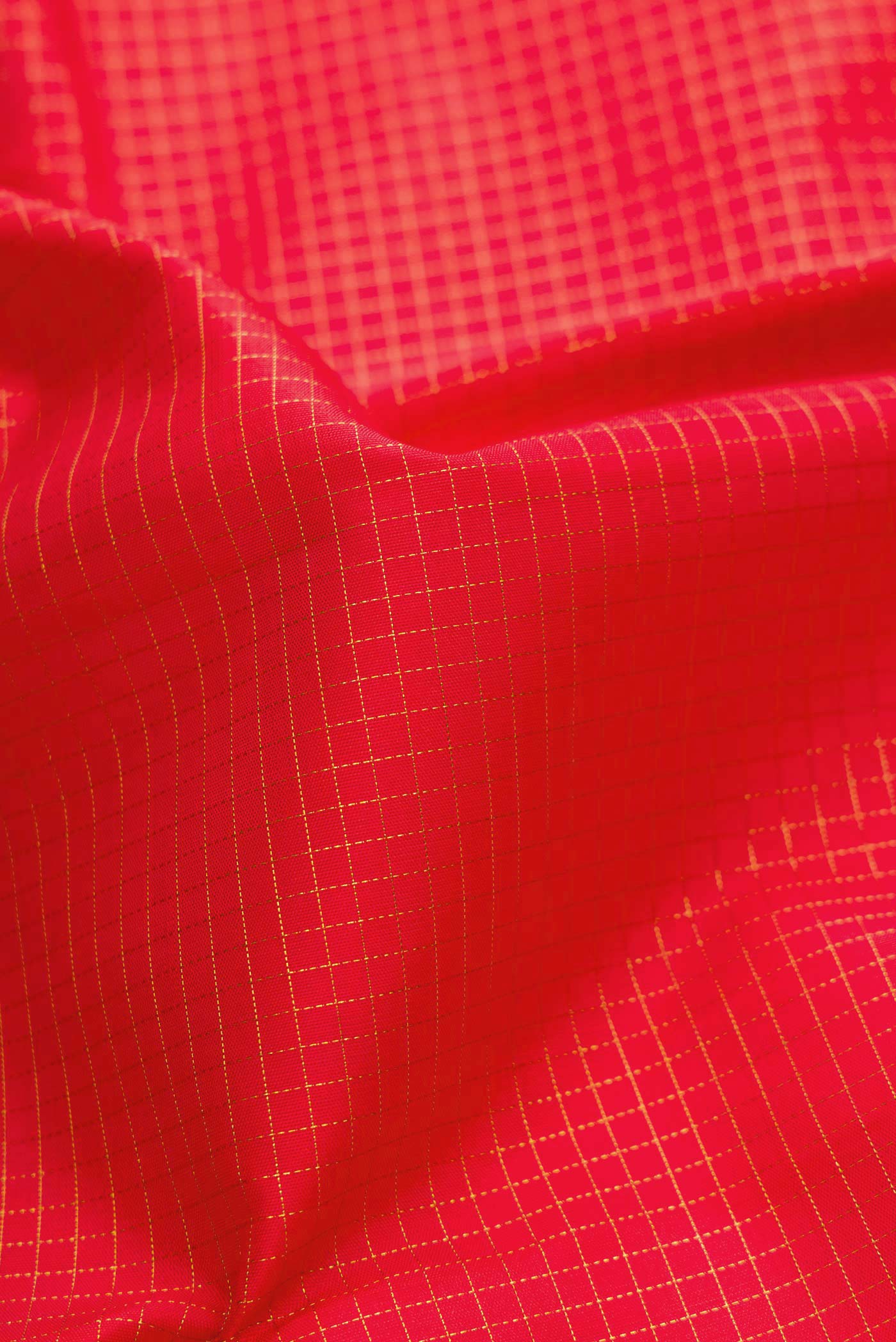 Close up of Pure Silk Pure Zari Red Dual Tone Kanchipuram Saree with Checked design on the body and Zari Border displaying folds