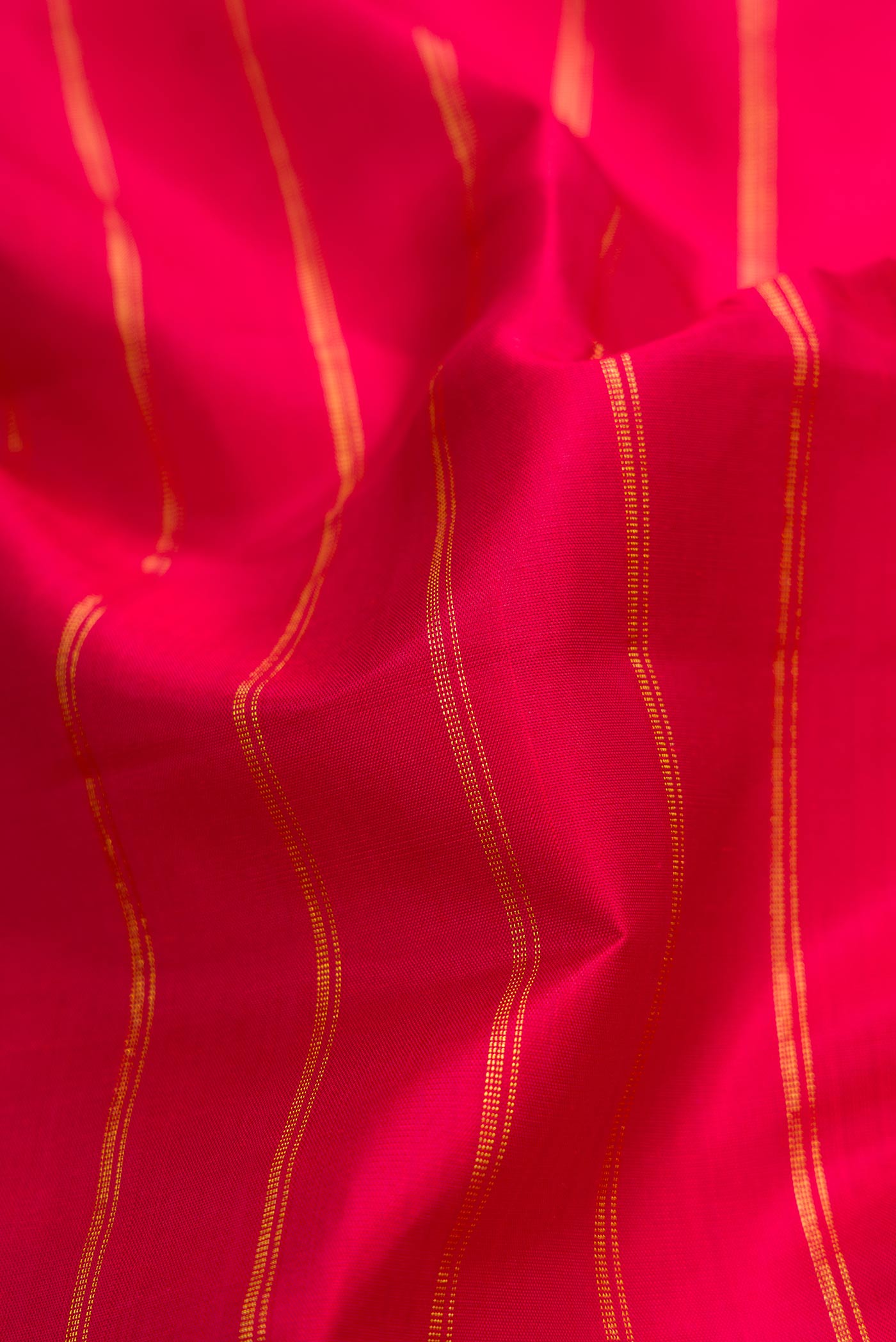 Close up of Maroon Dual Tone Kanchipuram Silk Saree with Stripes on the body and Zari Border displaying folds