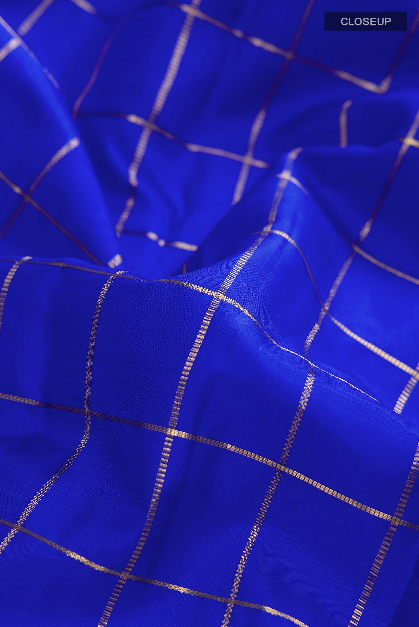 Close up of Blue Kanchipuram Silk Saree with Checked design on the body and Zari Border displaying folds