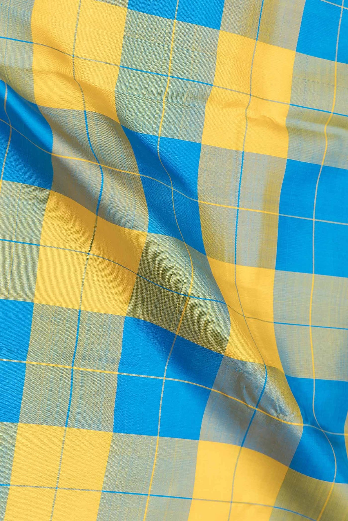 Close up of Yellow and Sky Blue Color Kanjivaram Saree with Checked design on the body and Ganga Jamuna Border.  displaying folds