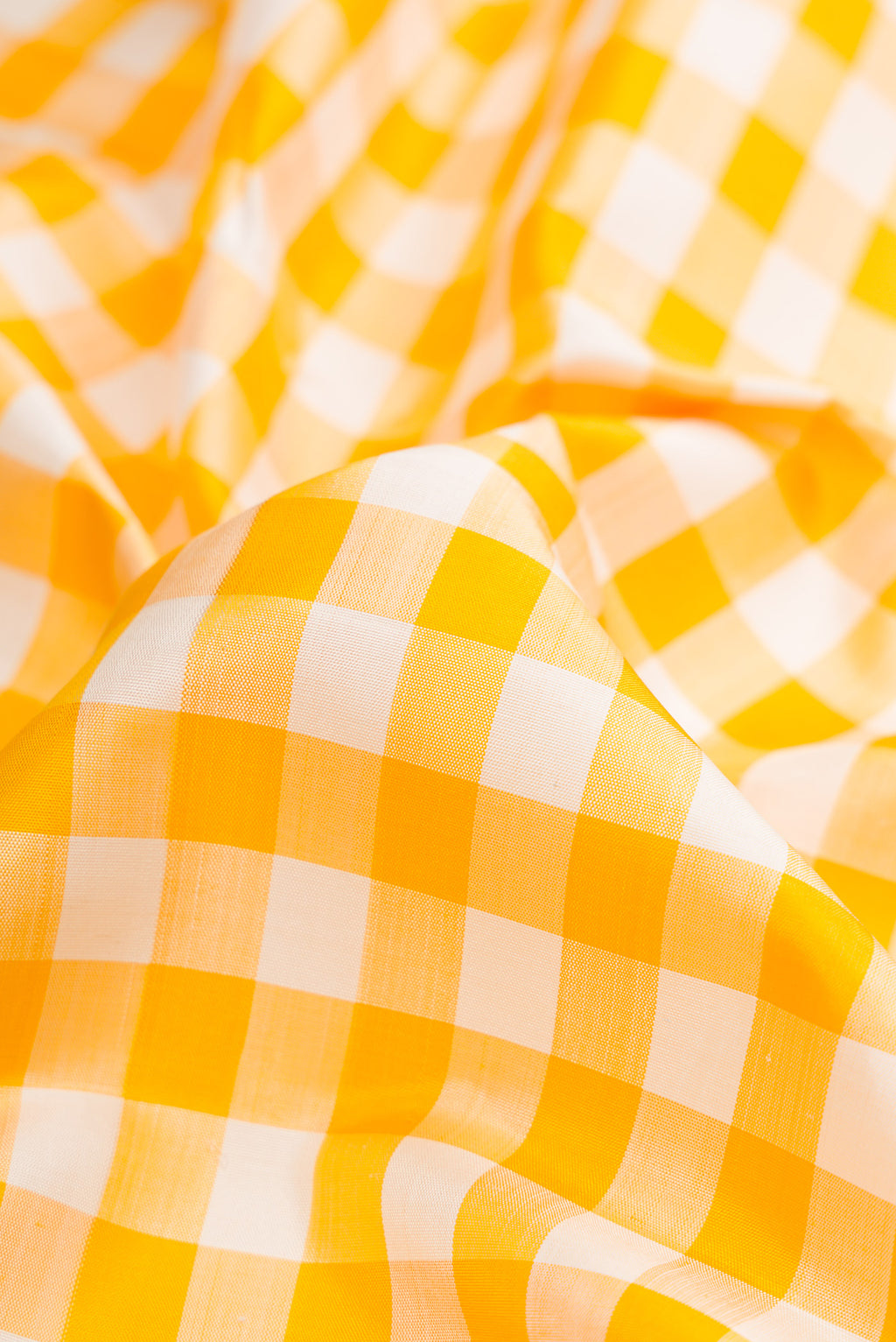 Close up of Pure Silk Pure Zari Off White and Musturd Color Kanchipuram Nine Yards Saree with Checked design on the body and Zari Border.  displaying folds