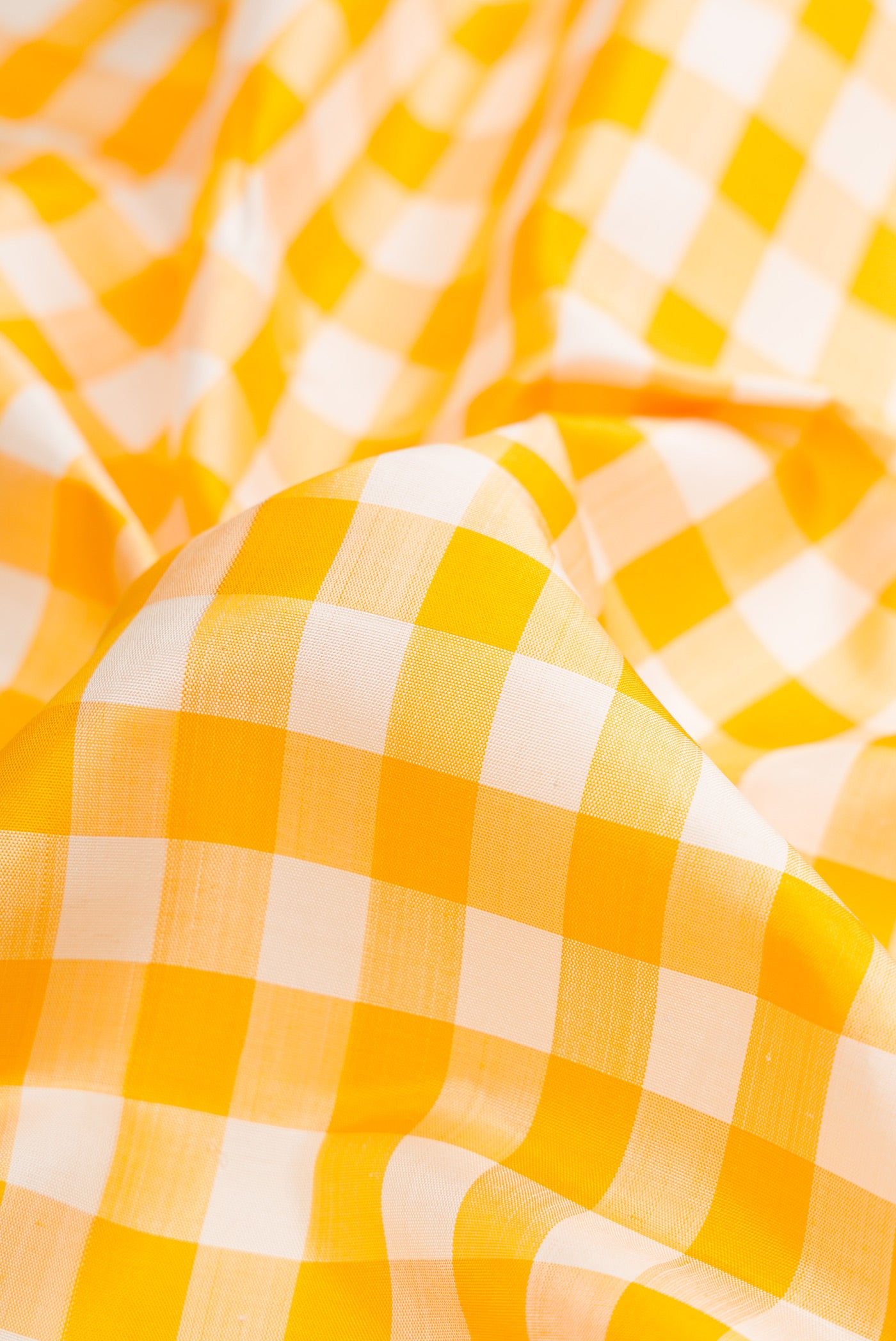 Close up of Pure Silk Pure Zari Off White and Musturd Color Kanchipuram Nine Yards Saree with Checked design on the body and Zari Border.  displaying folds
