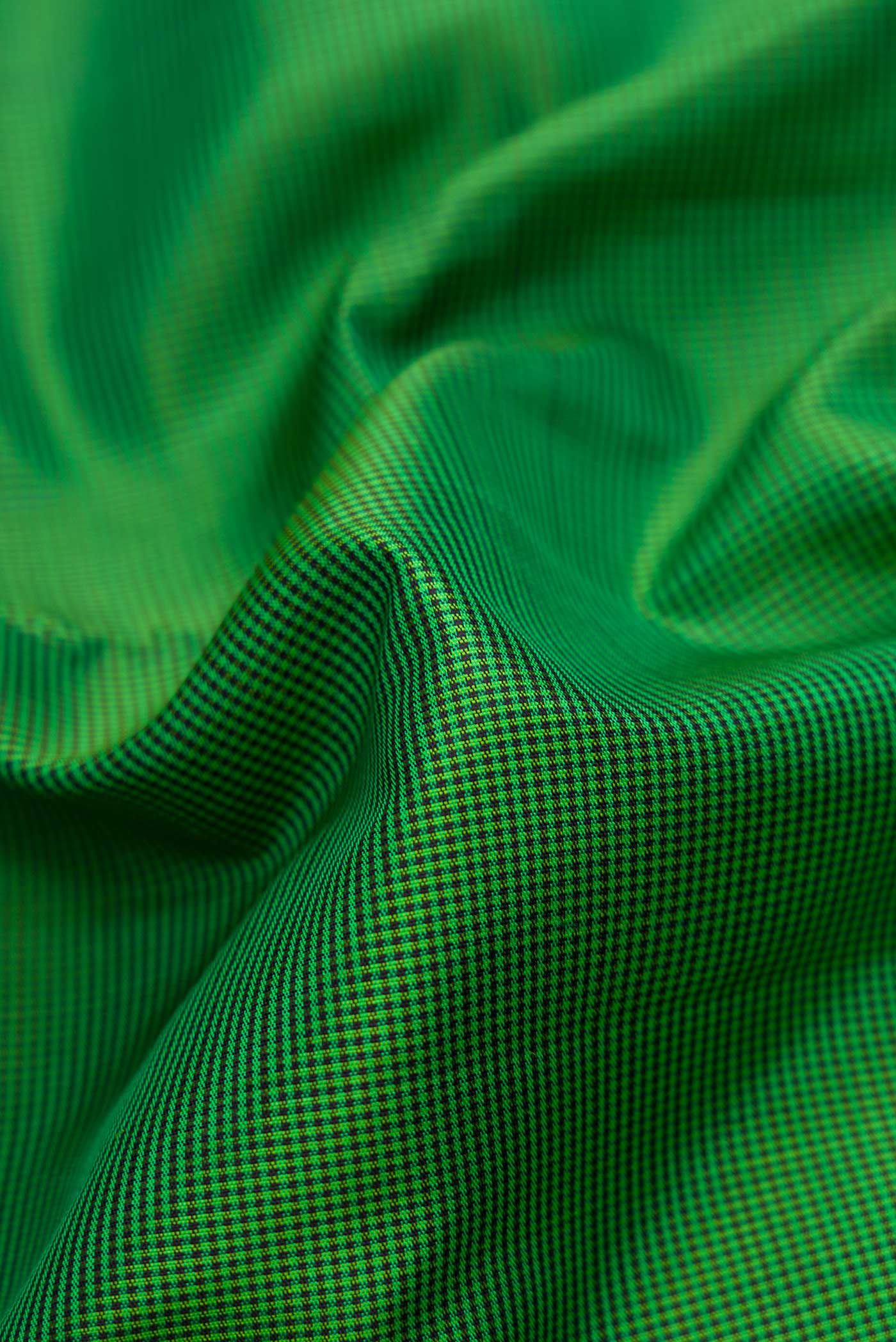 Close up of Green Dual Tone Kanchipuram Silk Saree with Checked design on the body and Zari Border displaying folds