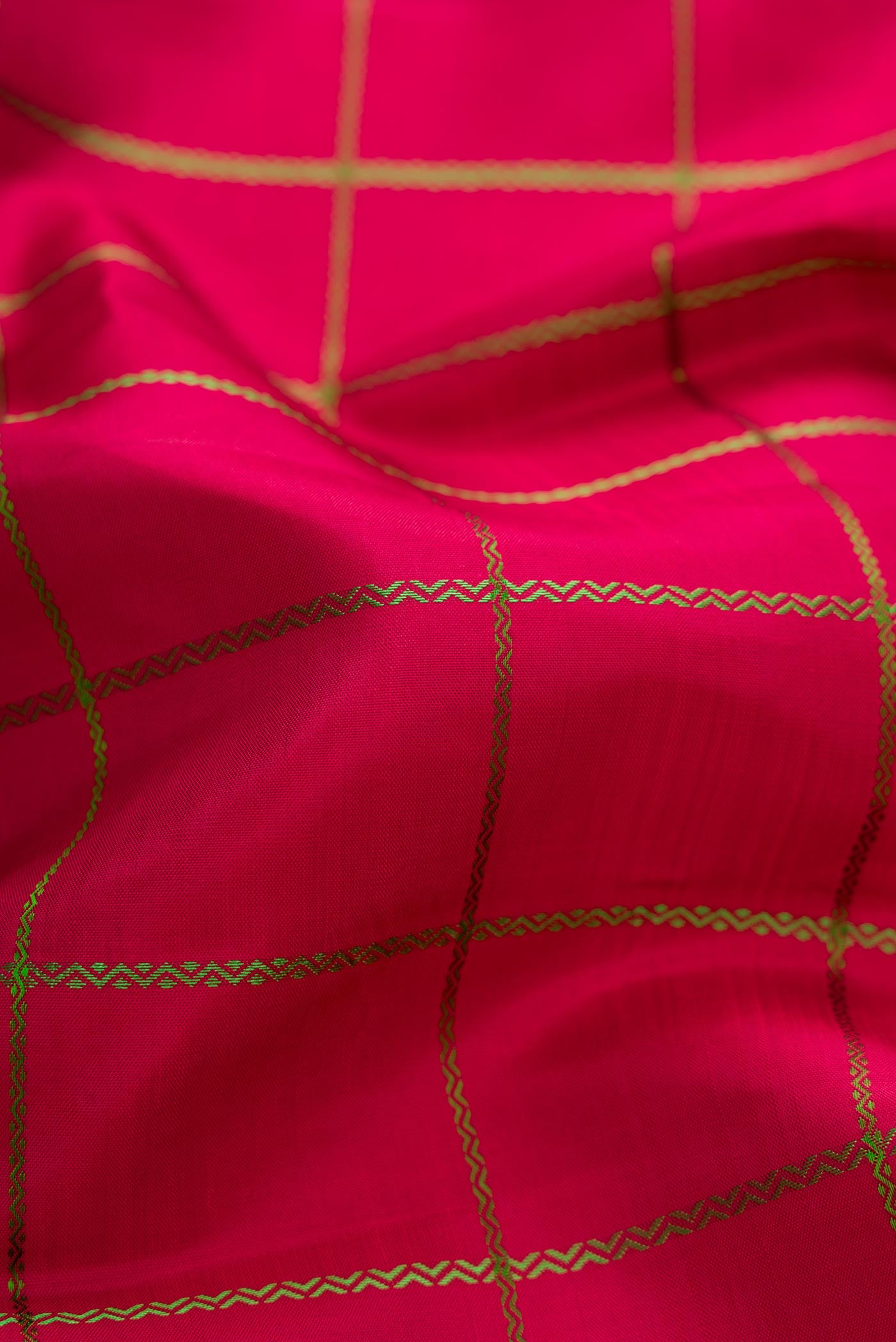 Close up of Maroon Dual Tone Kanchipuram Silk Saree with Checked design on the body and Zari Border displaying folds