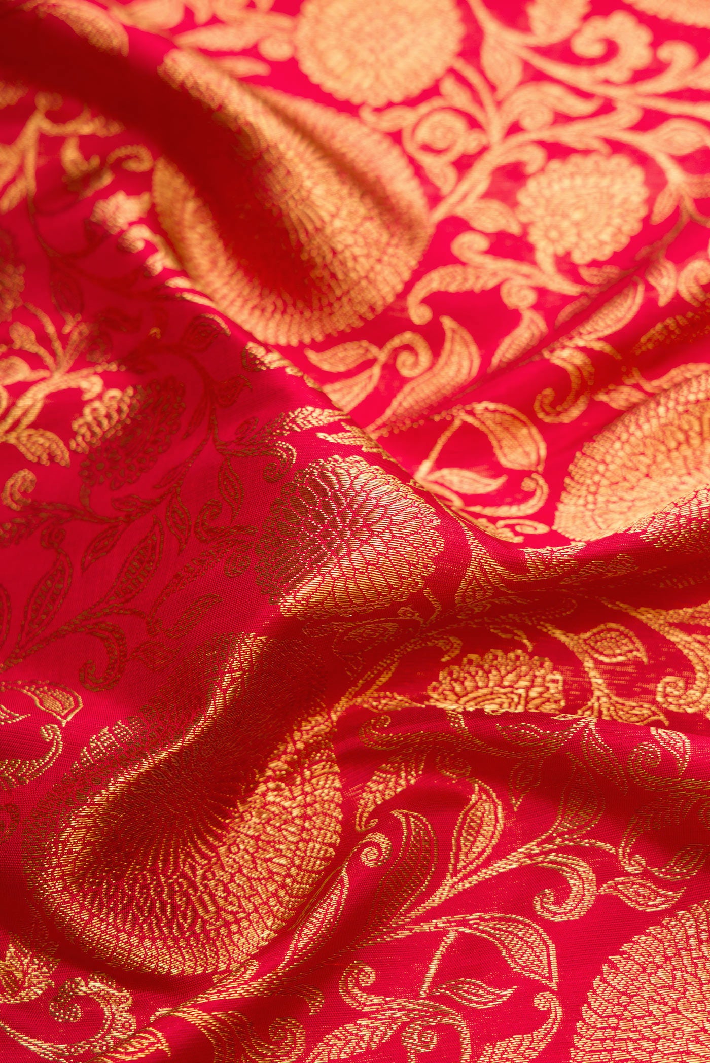Close up of Pure Silk Pure Zari Red Dual Tone Kanjivaram Saree with Zari Brocade on the body and Zari Border.  displaying folds