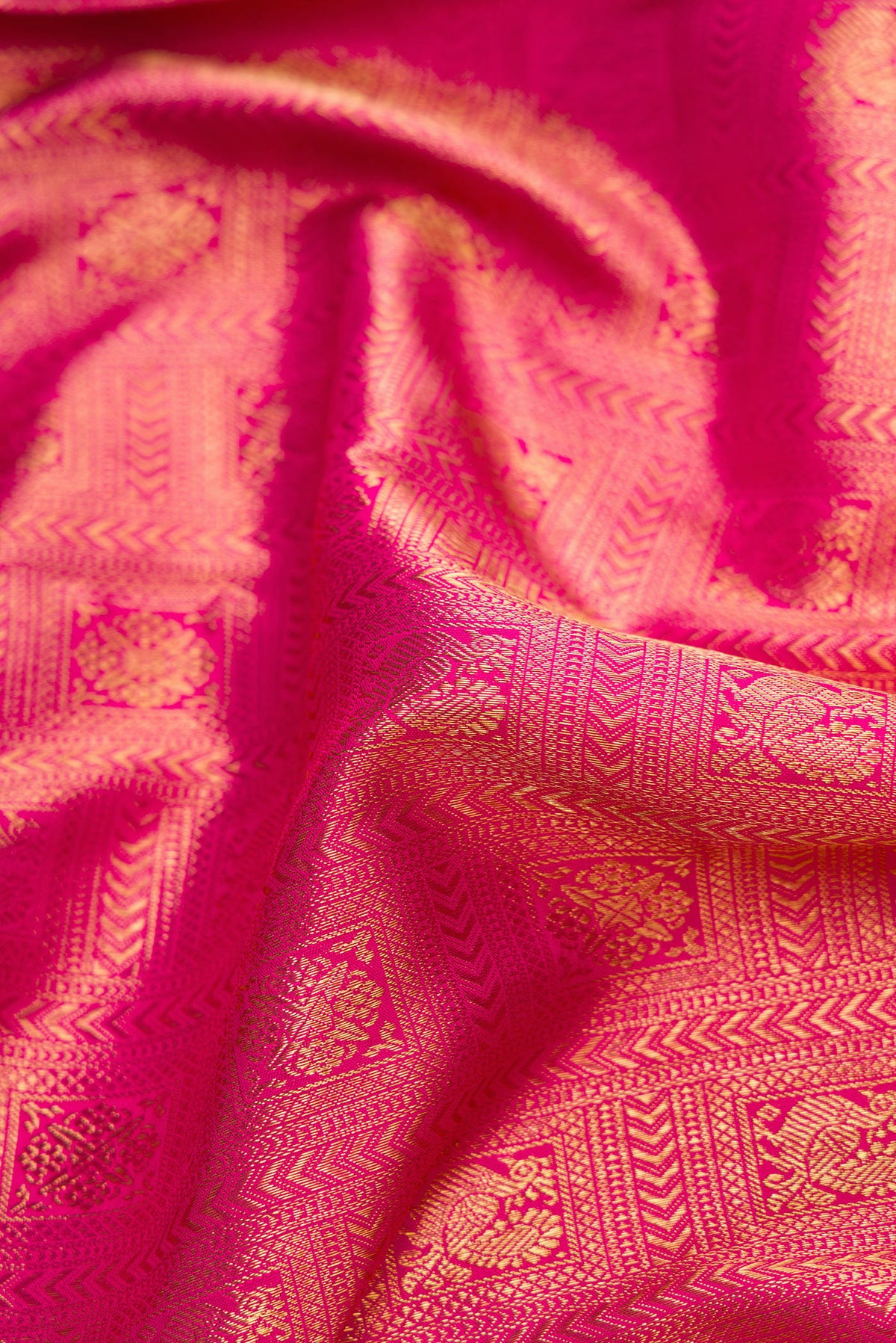 Close up of Pure Silk Pure Zari Pink Dual Tone Kanjivaram Saree with Zari Brocade on the body and Zari Border.  displaying folds