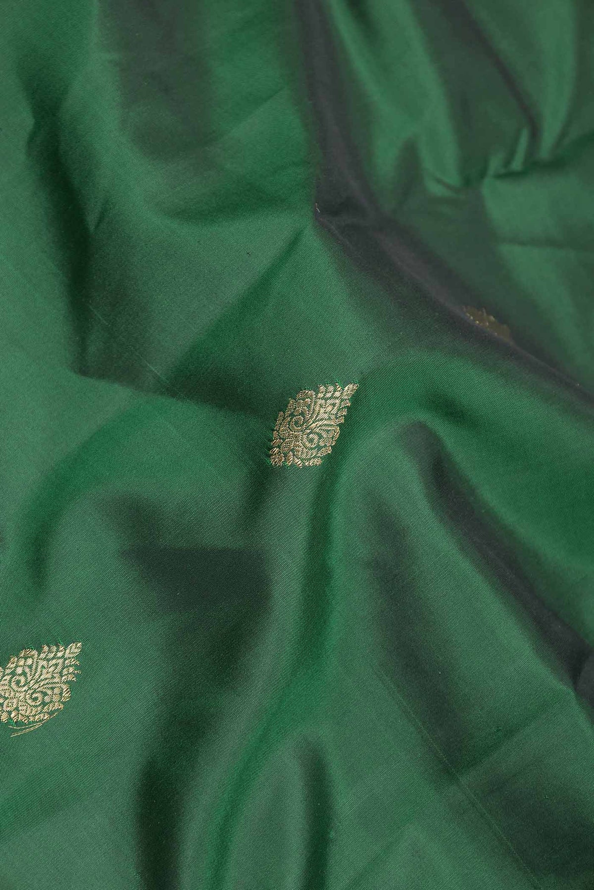 Close up of Pure Silk Pure Zari Green Dual Tone Kanchipuram Saree with Zari Butta on the body and Zari Border displaying folds