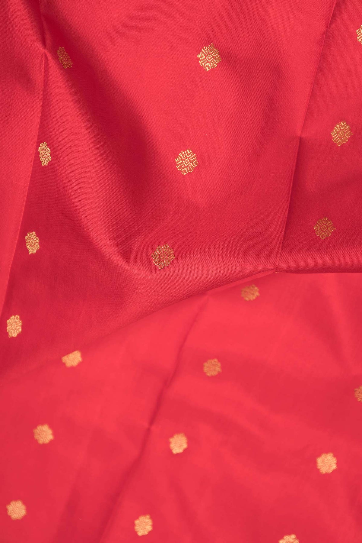Close up of Pure Silk Pure Zari Red Dual Tone Kanchipuram Saree with Zari Butta on the body and Zari Border displaying folds