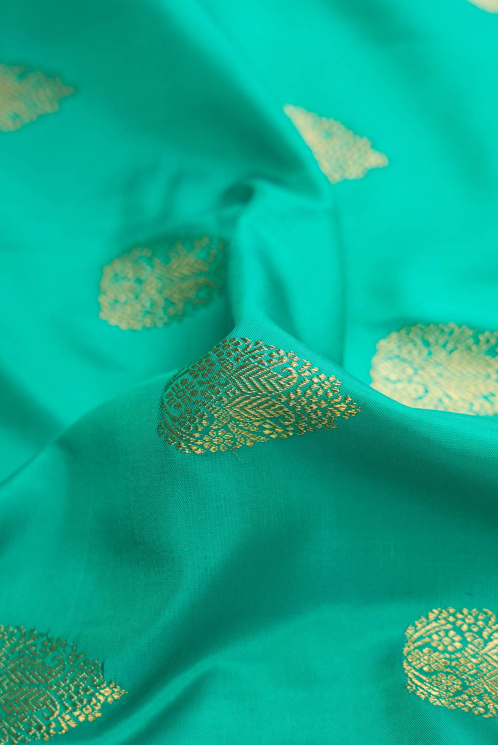 Close up of Pure Silk Pure Zari Sea Green Dual Tone Kanchipuram Saree with Zari Butta on the body and Zari Border displaying folds