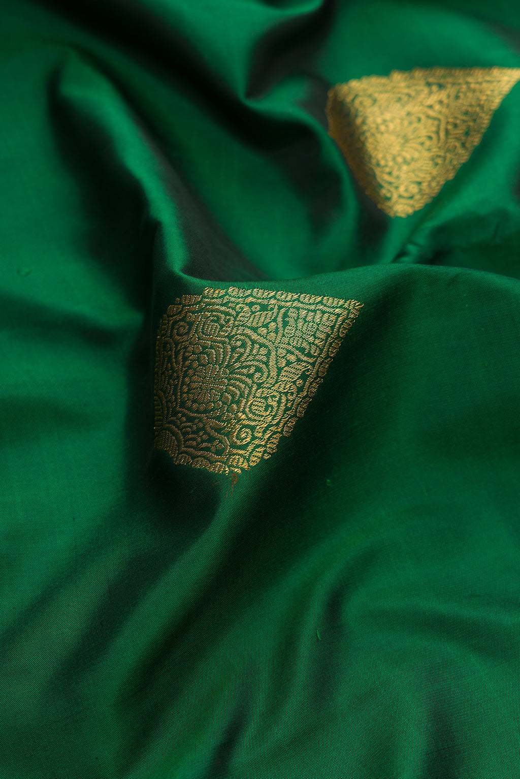 Close up of Pure Silk Pure Zari Green Kanjivaram Saree with Zari Butta on the body and Fancy Border.  displaying folds