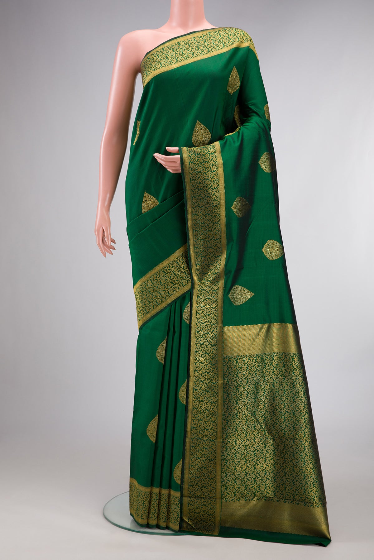 Pure Silk Pure Zari Green Kanjivaram Saree with Zari Butta on the body and Fancy Border.  displayed on a mannequin