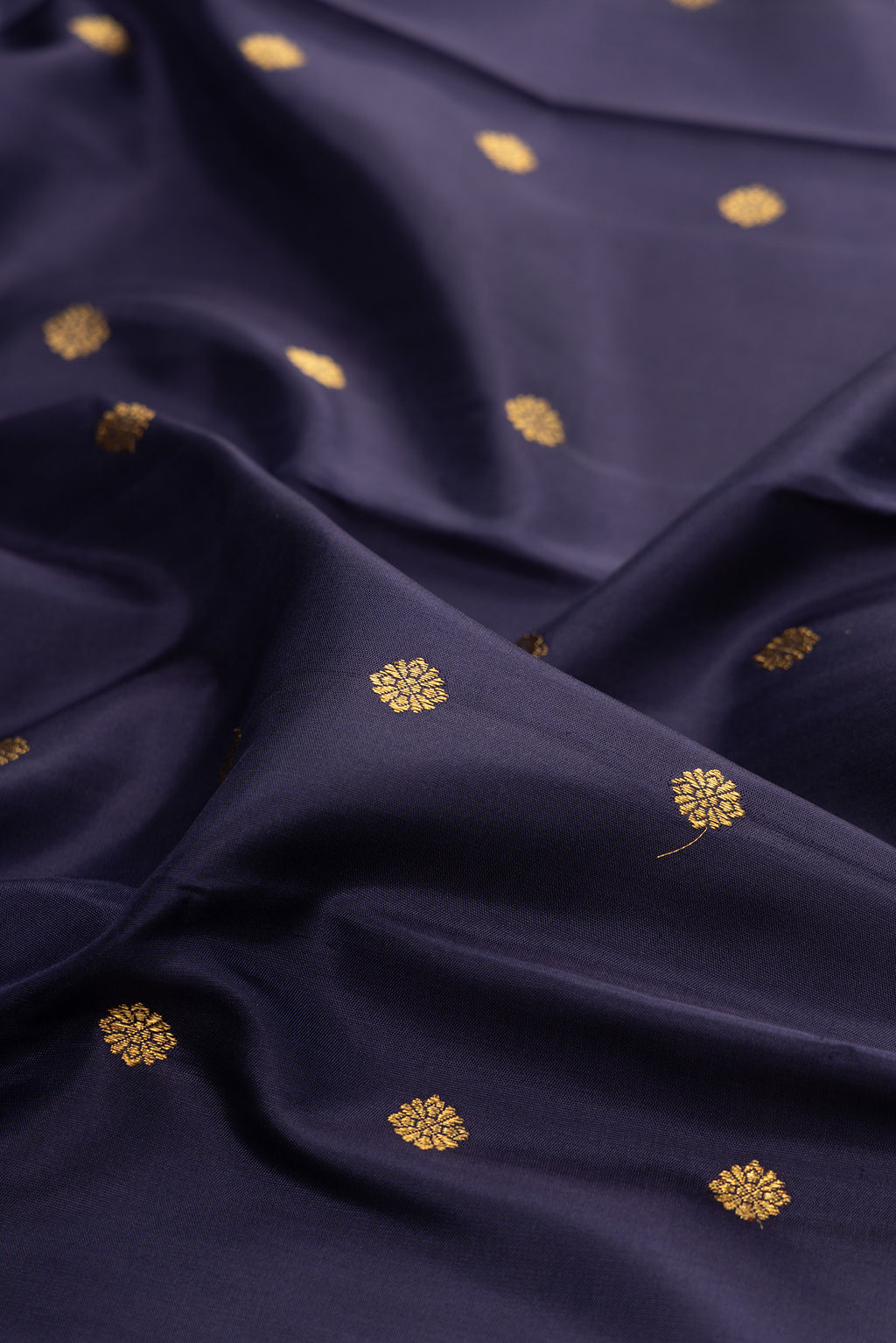 Close up of Pure Silk Pure Zari Navy Blue Kanjivaram Saree with Zari Butta on the body and Zari Border.  displaying folds