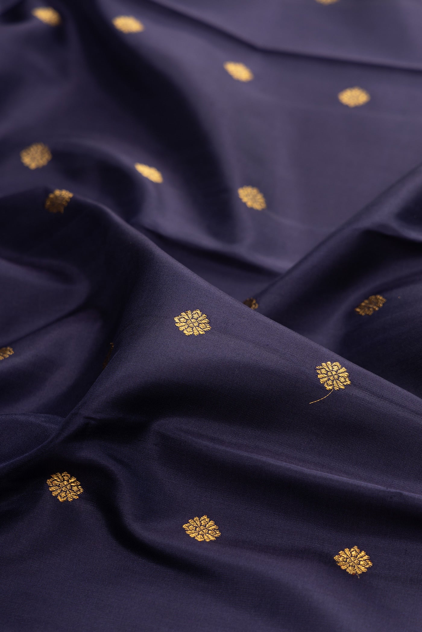 Close up of Pure Silk Pure Zari Navy Blue Kanjivaram Saree with Zari Butta on the body and Zari Border.  displaying folds