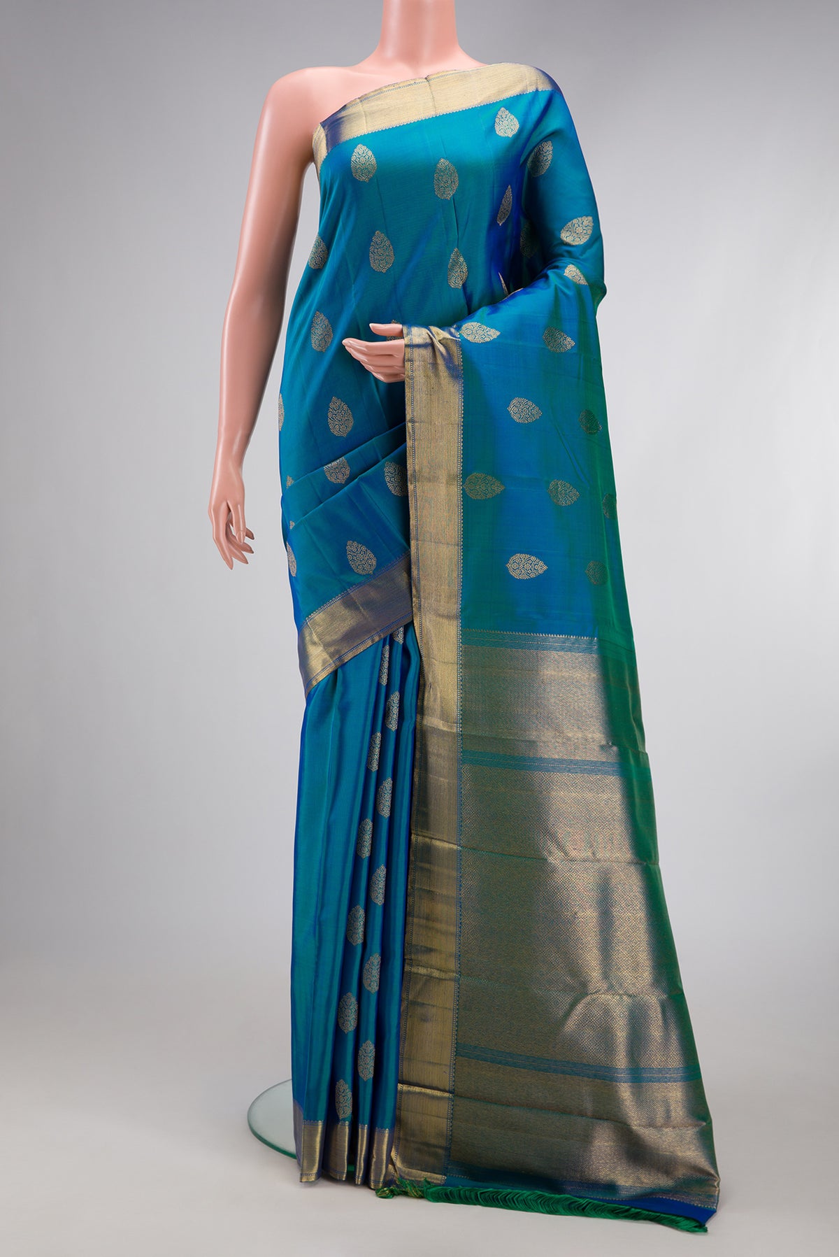 Pure Silk Pure Zari Peacock Blue Dual Tone Kanjivaram Saree with Zari Butta on the body and Zari Border.  displayed on a mannequin