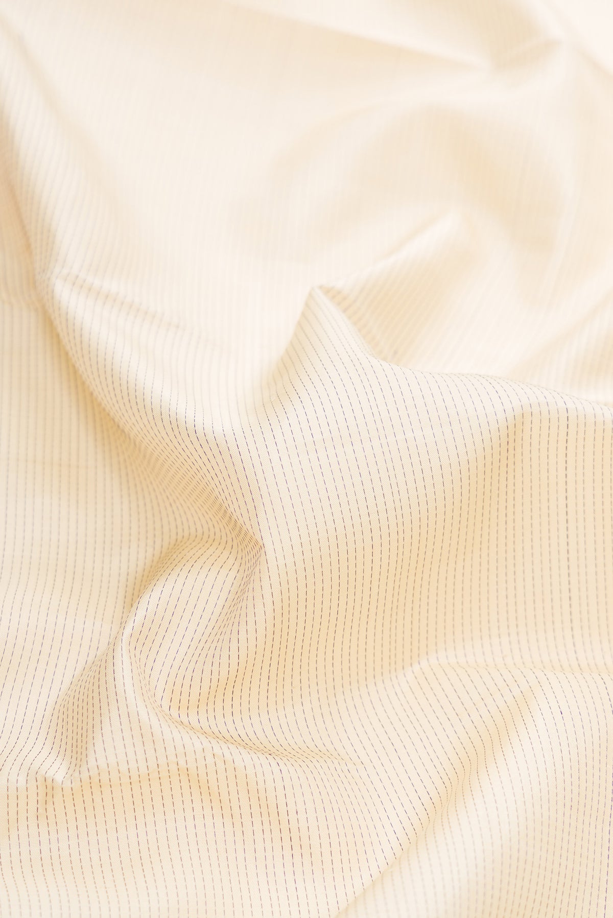 Close up of Pure Silk Pure Zari Off White Dual Tone Kanjivaram Saree with Stripes on the body and Zari Border.  displaying folds
