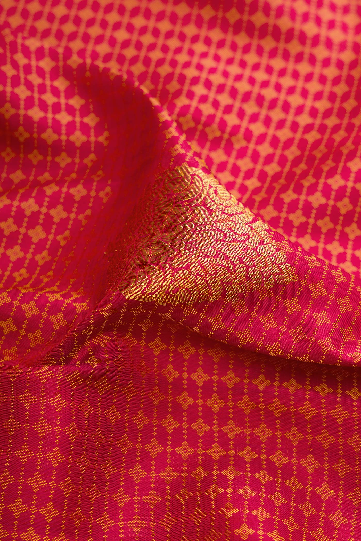 Close up of Maroon Dual Tone Kanjivaram Silk Saree with Jacquard design on the body and Zari Border.  displaying folds