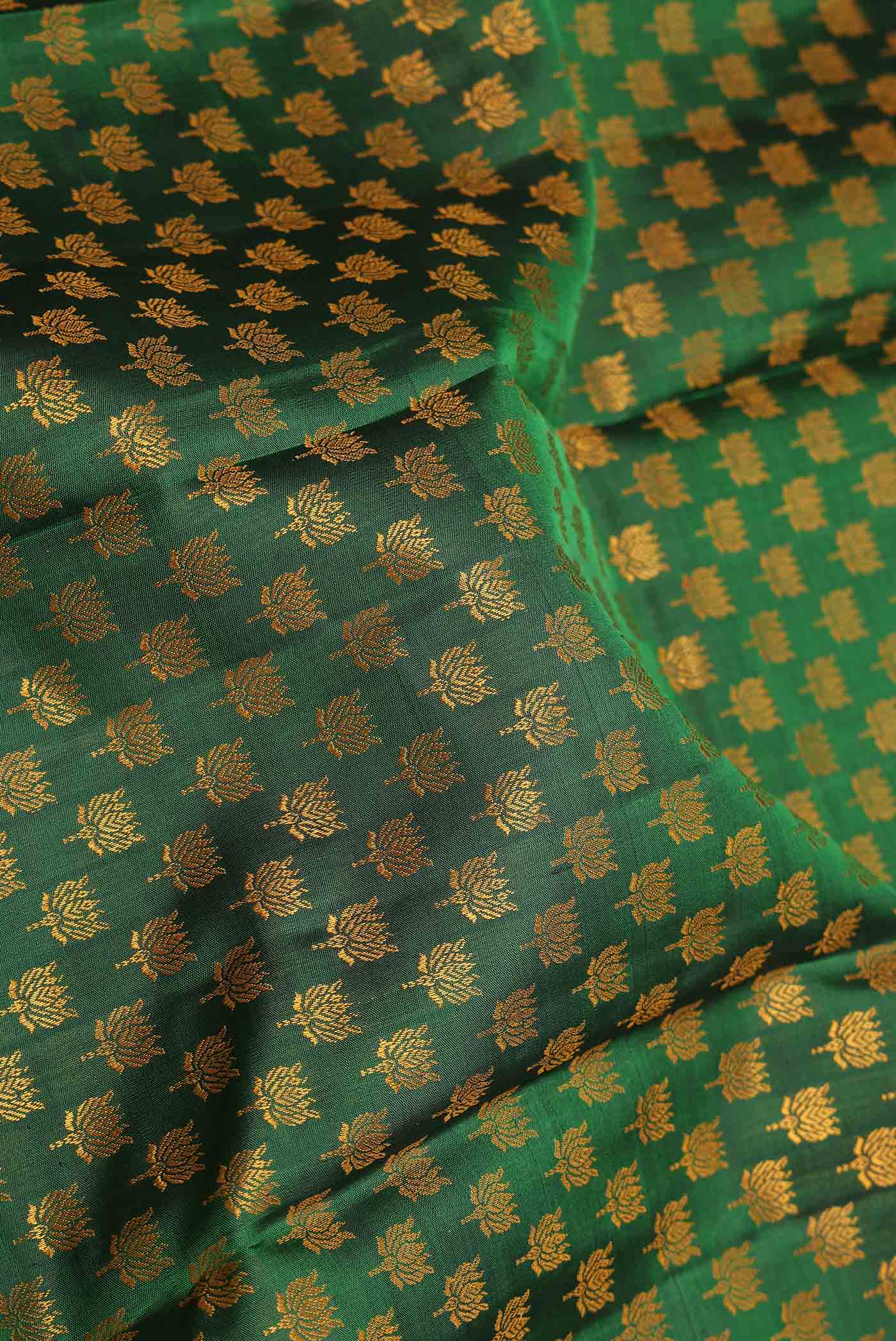 Close up of Pure Silk Pure Zari Green Dual Tone Kanchipuram Saree with Thread Butta on the body and Zari Border displaying folds