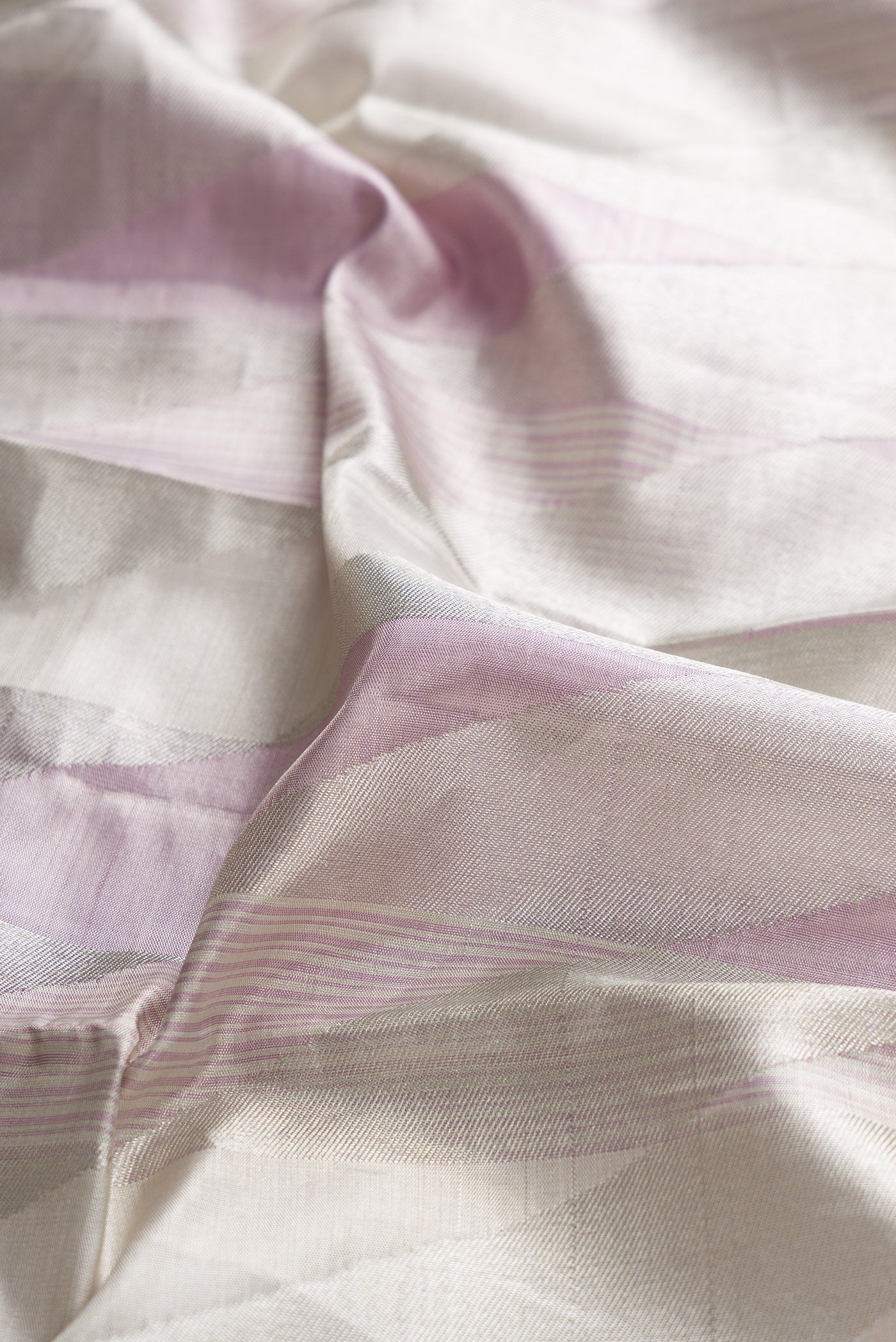 Close up of Silver Dual Tone Kanjivaram Tissue Silk Saree with Zari Brocade on the body and Zari Border.  displaying folds