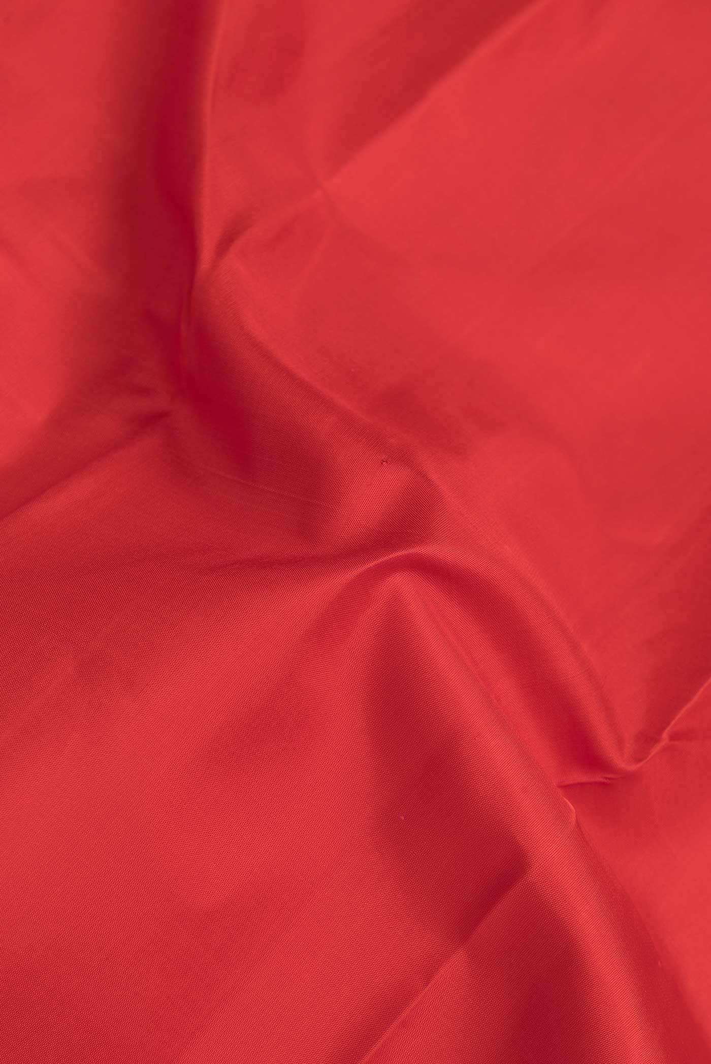 Close up of Red Dual Tone Kanchipuram Silk Saree with Plain Body and Temple Border.  displaying folds
