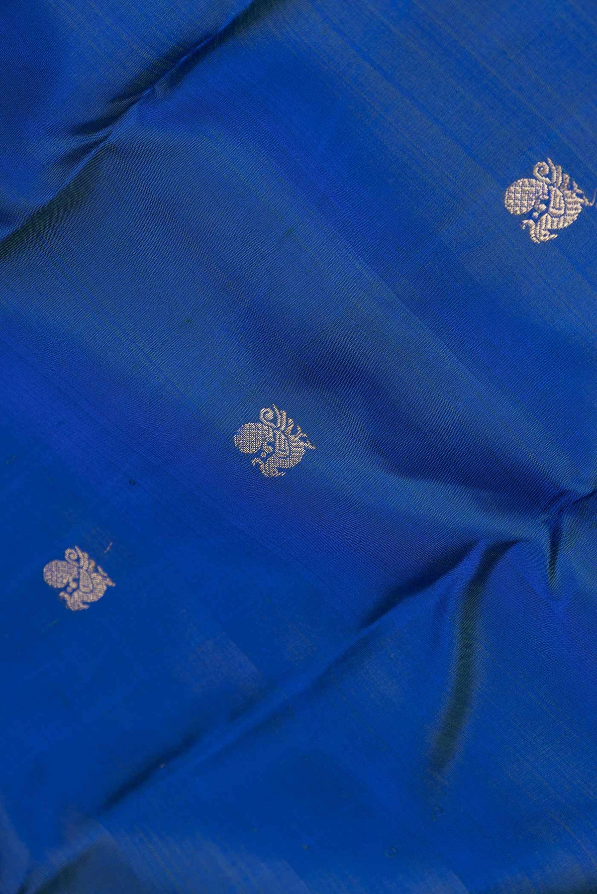 Close up of Pure Silk Pure Zari Royal Blue Dual Tone Kanchipuram Saree with Zari Butta on the body and Zari Border displaying folds